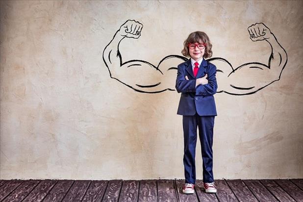 Kid in suit with illustration of muscular arms behind him