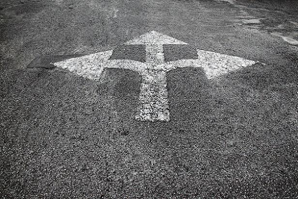 Asphalt with painted arrows pointing in three directions, representing the paths HR pros can take in their careers