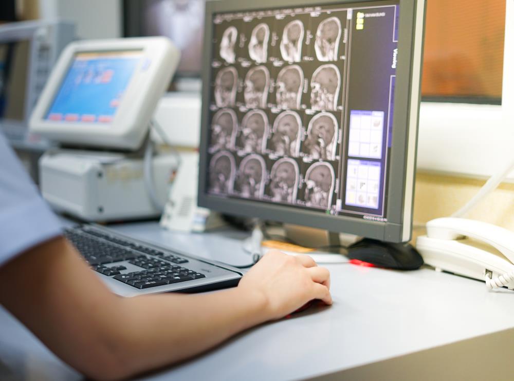 radiologic technologist examining images on a computer