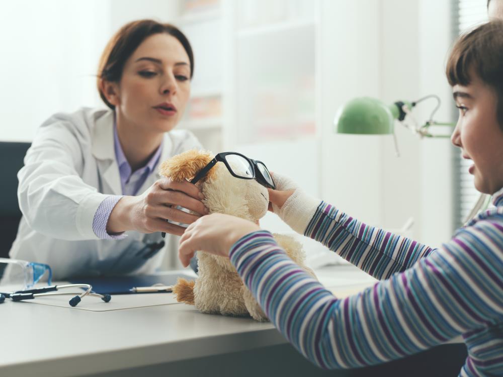 Optometric assistant working patiently with a child