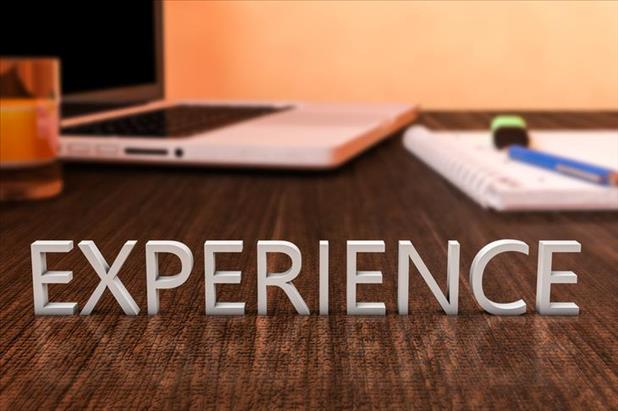 Experience spelled out on desk in front of laptop and papers