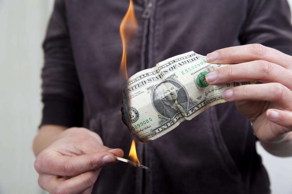 Man burning a dollar bill