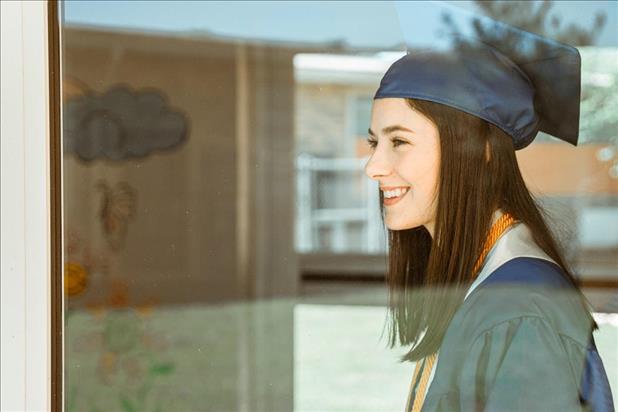 smiling new grad wearing her cap at graduation