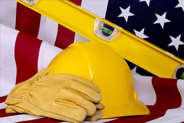 construction hat, gloves, and level sitting in front of the american flag