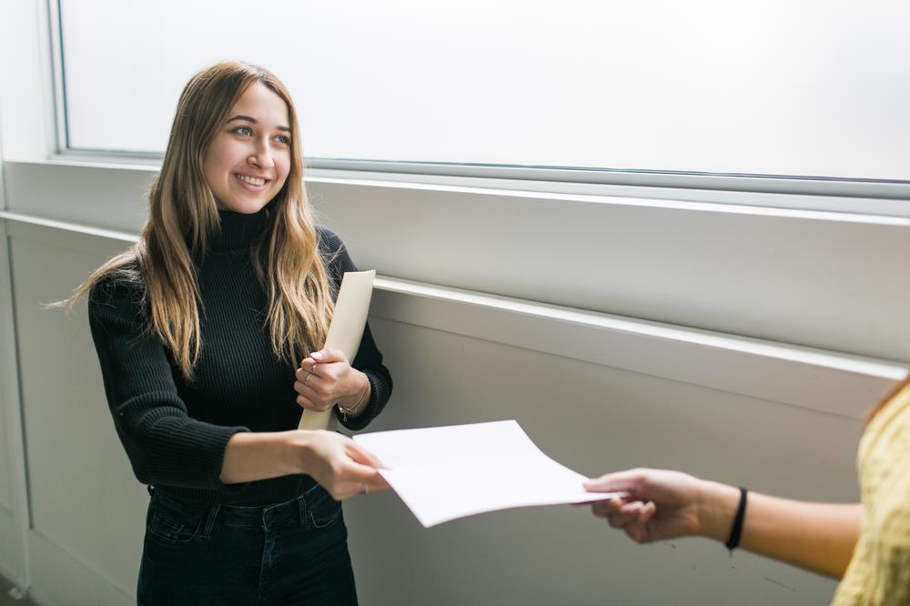 Woman giving her resume to a friend to review