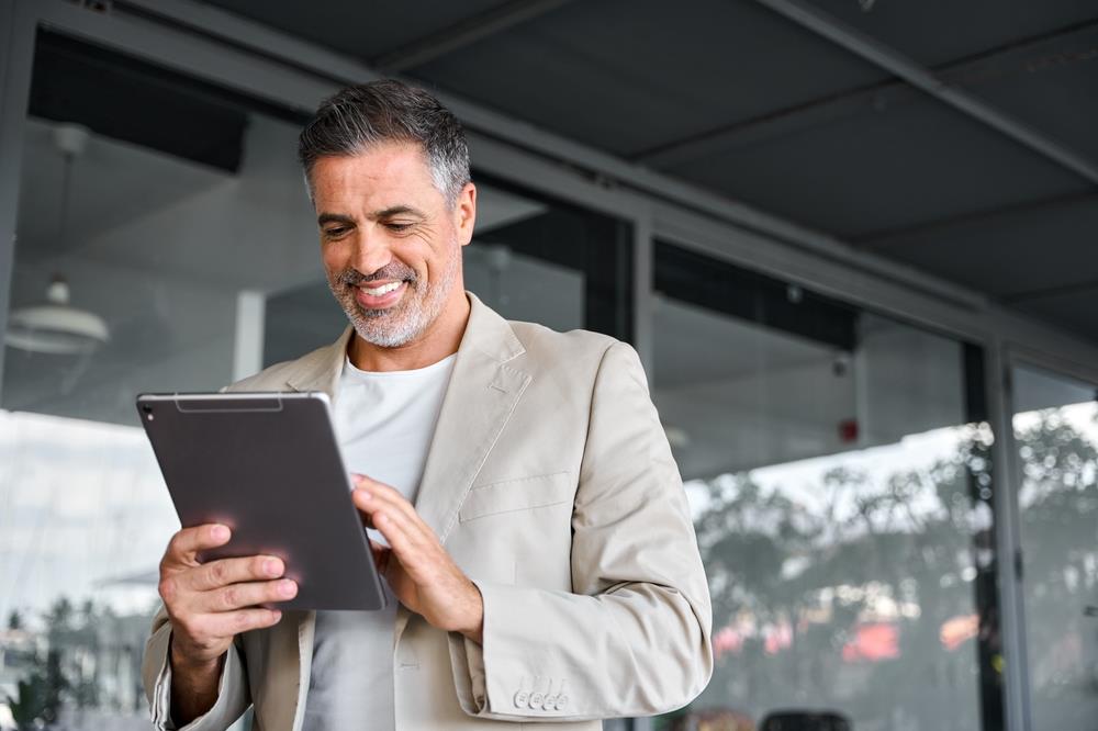 mature job seeker applying to jobs on his tablet