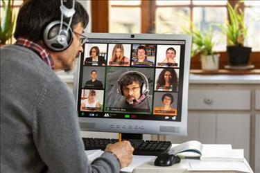 man looking at computer with virtual team on screen