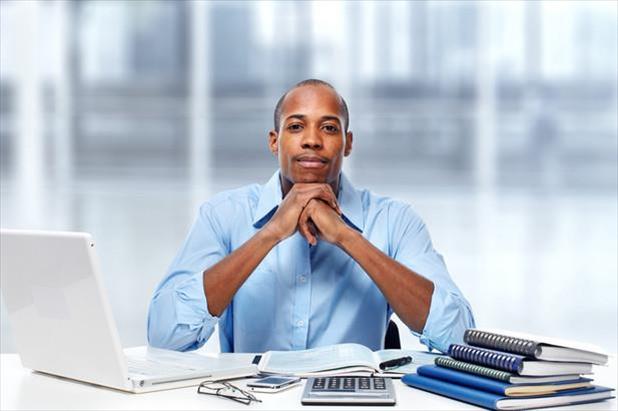 Accountant posing at desk surrounded by work materials