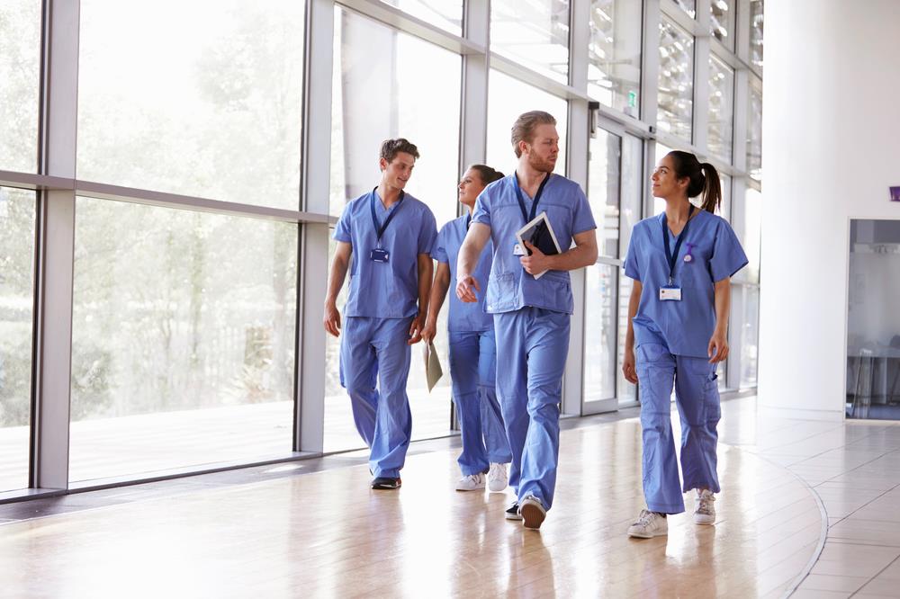 team of healthcare professionals walking down a hospital hallway