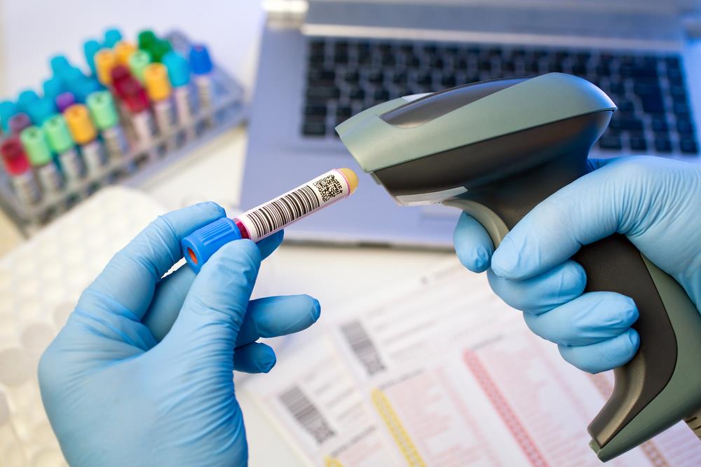 phlebotomy technician scanning the barcode on a blood sample vial