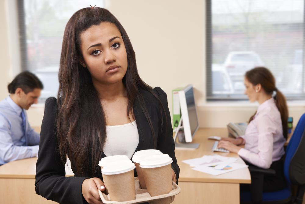 unhappy intern holding coffee and frowning at the camera
