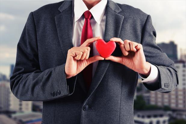 man in suit holding a heart