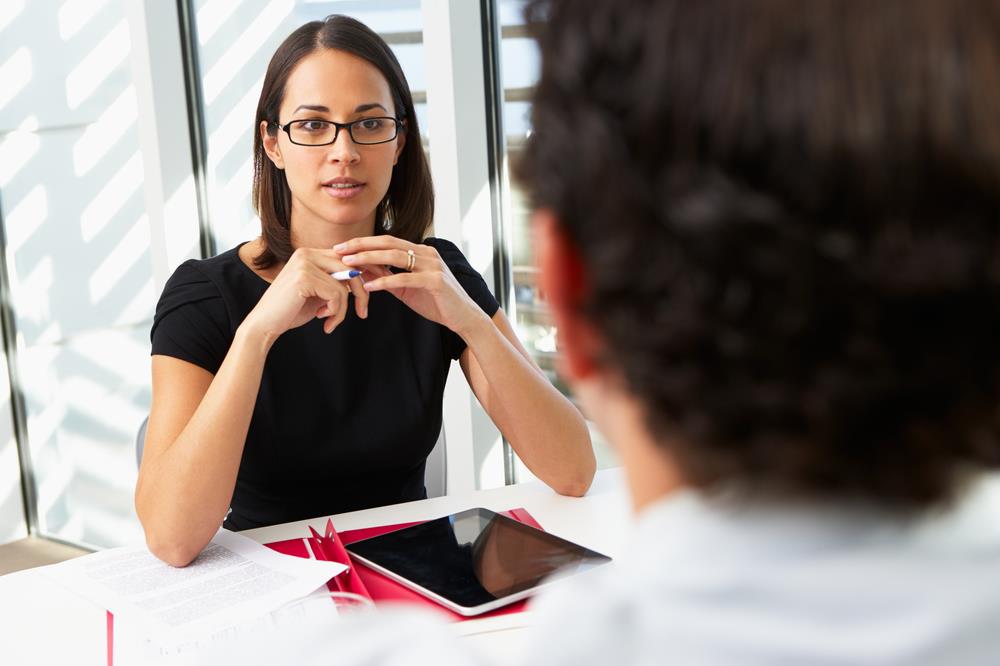 female interviewer listening to a male job candidate answer her question
