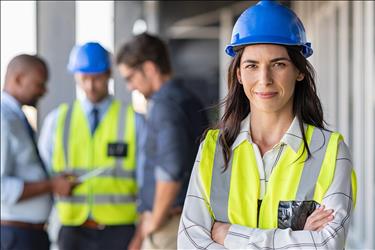 group of construction workers with woman in a blue hardhat smiling