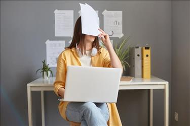 new employee covering her face with paperwork