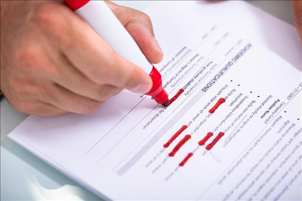 job seeker editing their resume with a red marker
