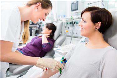 phlebotomist drawing blood from a patient