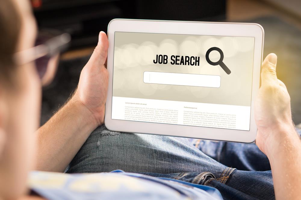 job seeker searching for opportunities online on his tablet