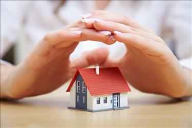 insurance agent's hands over a small house