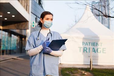 healthcare worker wearing a mask outside of a patient triage tent