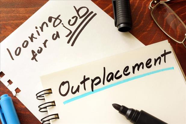 "Outplacement" and "looking for a job" written on a notepad