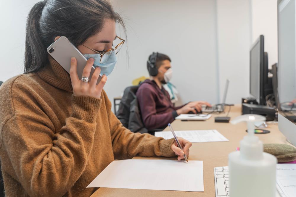 employees safely returning to work by practicing social distancing and wearing masks