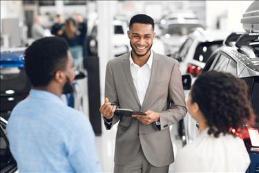 Automotive sales manager greeting customers