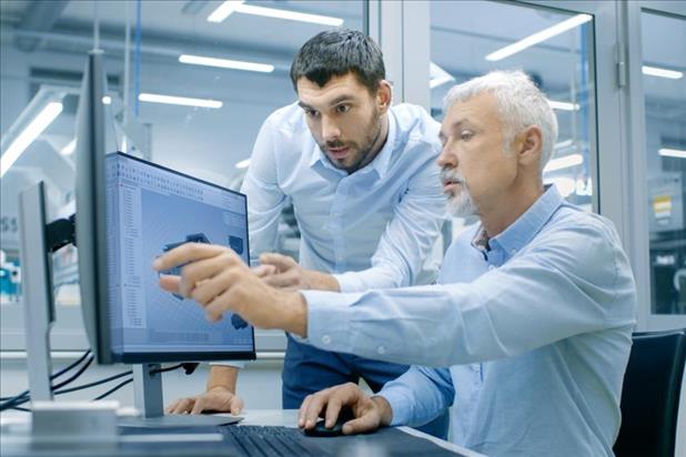 two mechanical engineers reviewing plans on a computer monitor