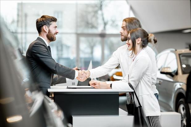 salesperson shaking hands with happy clients 