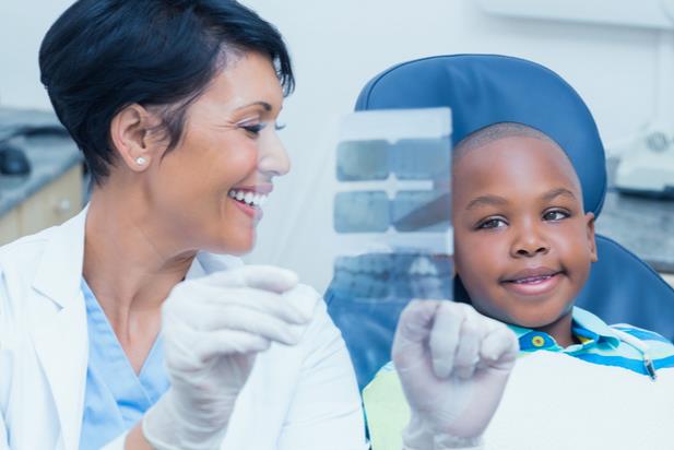 dental hygienist showing young patient an x-ray