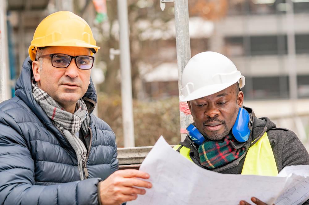 construction project manager reviewing site plans with a crew member