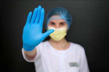 medical professional holding up their hand in a stop gesture