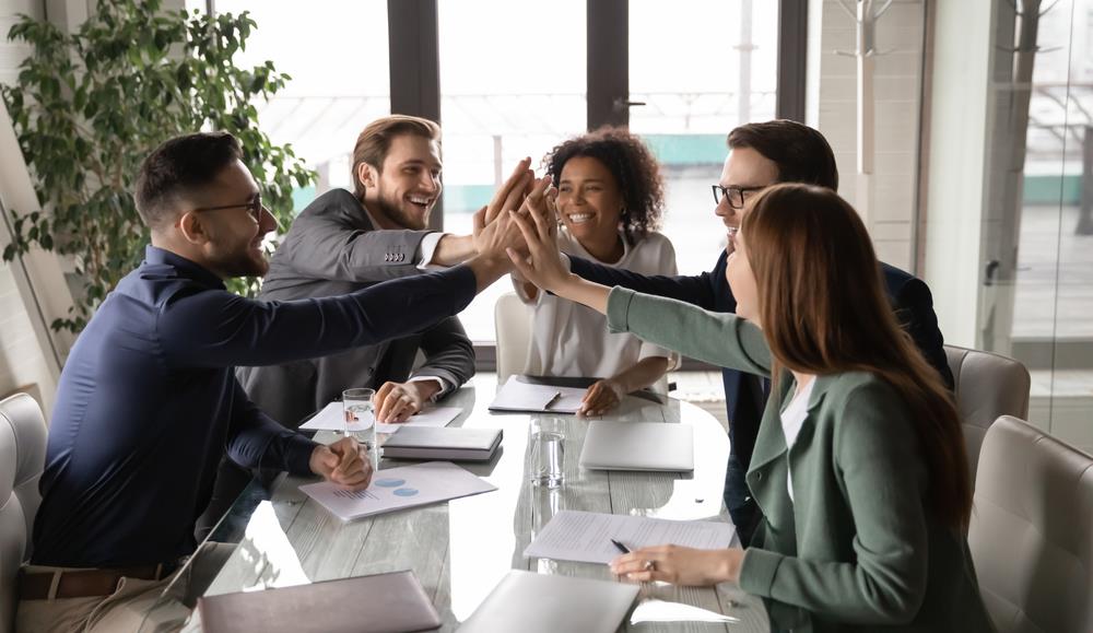 Employees high fiving in meeting