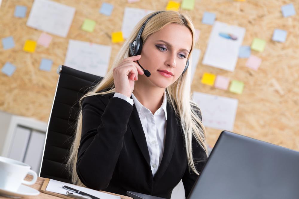receptionist answering phones via a headset at her desk