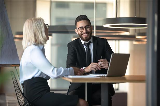 Employee and boss smiling while having conversation