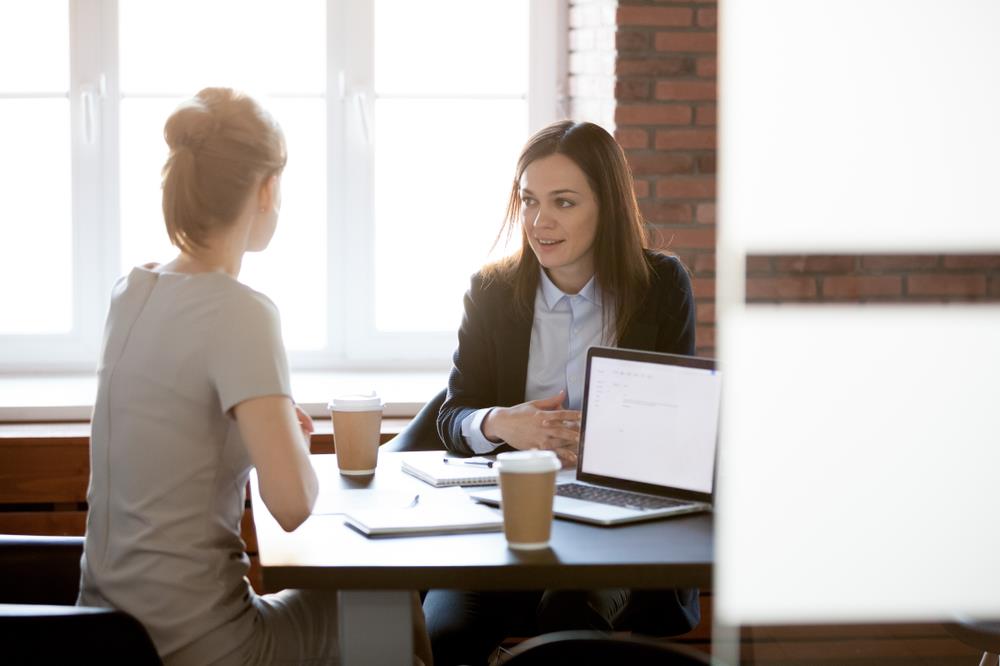 Woman having a private conversation with her smiling boss