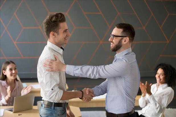 employee shaking hands with his supervisor after being promoted from part-time to full-time