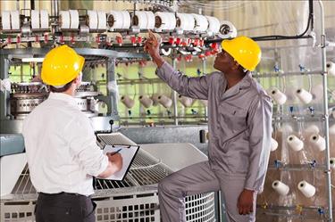 Quality control professionals inspect manufacturing equipment