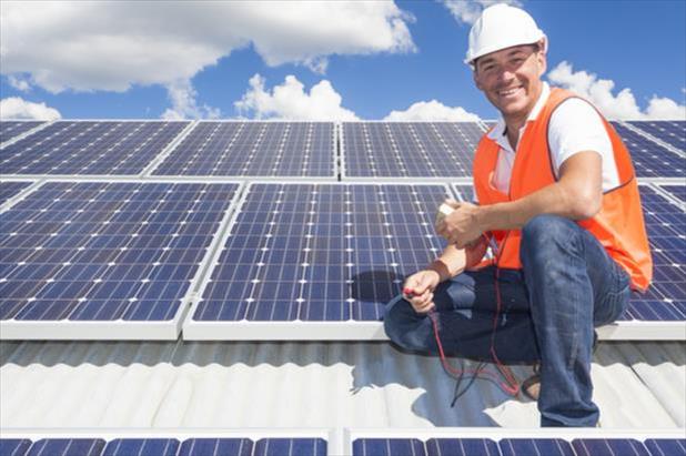 Smiling solar installation technician who enjoys working in the utilities industry