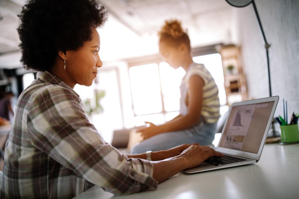 Mother working from home to supervise her daughter