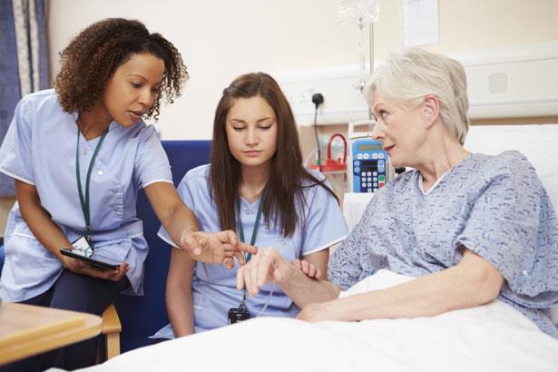 Image of nurse being mentored while examining a patient