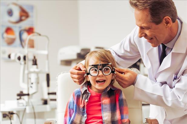 optometrist conducting an eye test on child patient