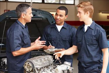 Mechanic apprentices learning from master